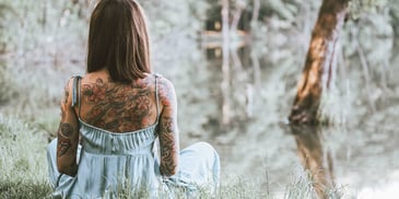 woman meditating by a peaceful river