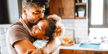 father hugging daughter in kitchen