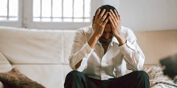 man sitting with head in hands
