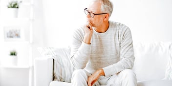 man sitting alone and thinking on a white couch