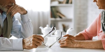 older couple having a serious conversation at a table