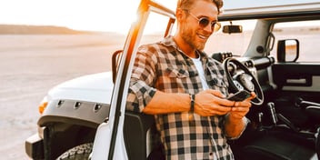 man standing outside a Jeep in the desert