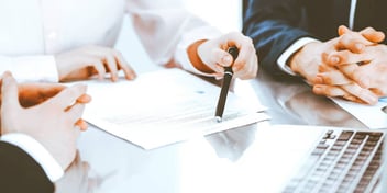 Close-up of three men reviewing a document together