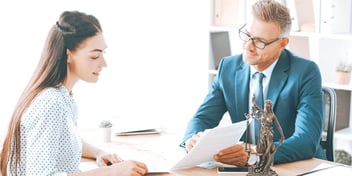 lawyer and client meeting in an office going over paperwork