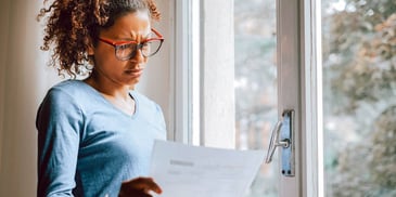 woman looking confused and holding a piece of paper