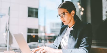 Young woman working on her laptop wearing a suit