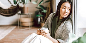 young woman sitting on the floor with a cup of tea