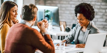 Young Black woman reviewing paperwork with young couple